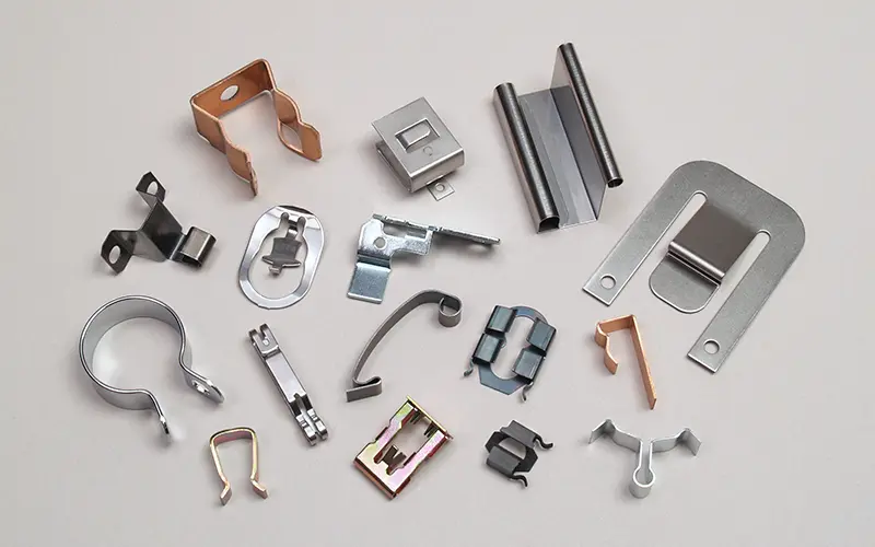 Clips, clasps, clamps and springs made with the fourslide process